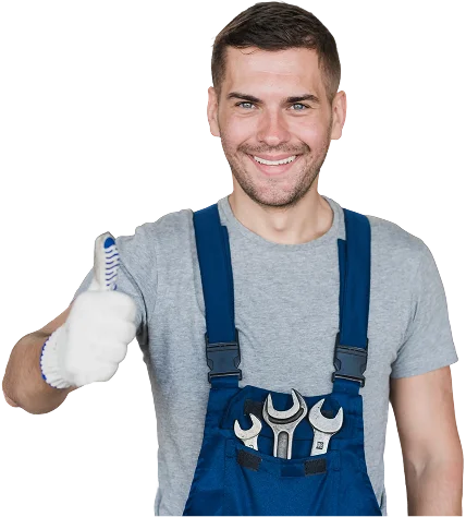 Un mécanicien souriant vêtu d'une combinaison bleue lève le pouce dans un garage. Il a des outils dans les poches et le capot d'une voiture est ouvert derrière lui. Ambiance positive et confiante